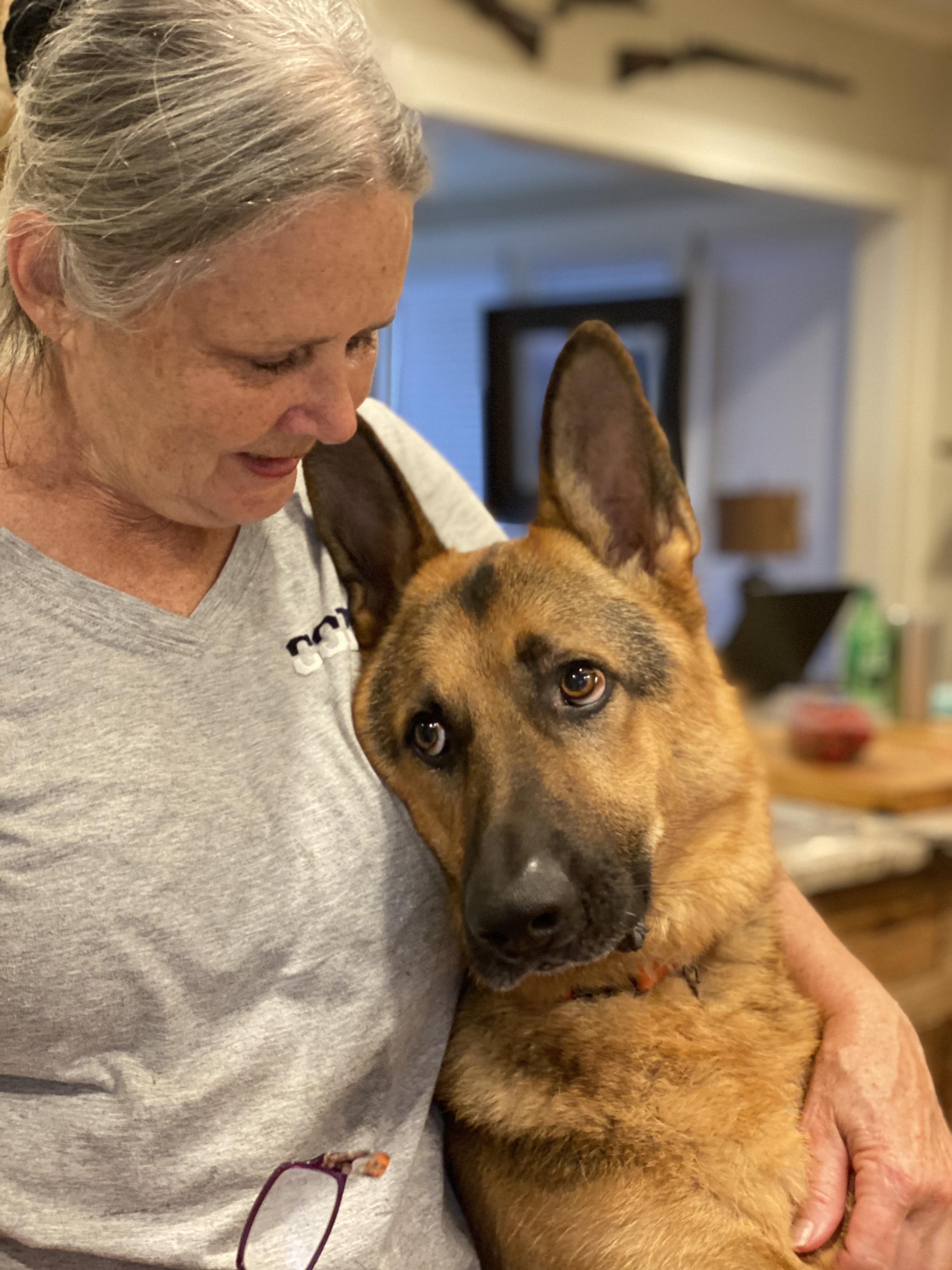 A woman cradling her dog in a moment of quiet connection