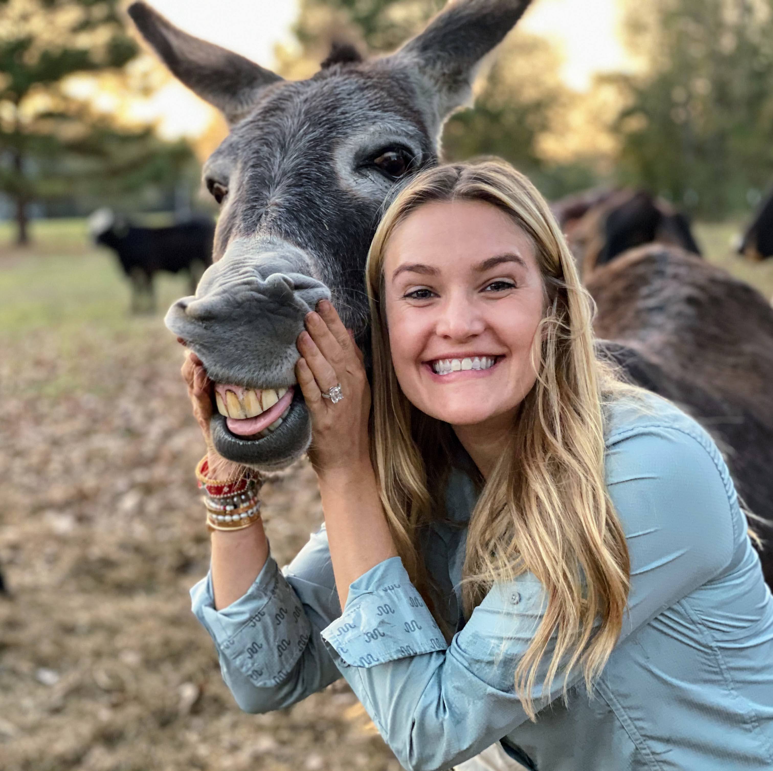 A woman standing beside her horse in gentle companionship